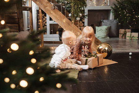 友谊装饰摄影照片_圣诞节前夕，弟弟和妹妹在一栋为新年假期装饰的漂亮房子里玩耍。