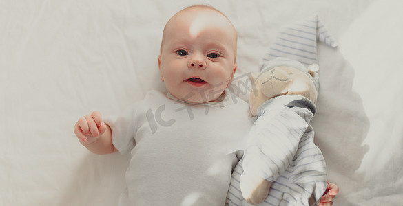 婴儿躺在婴儿床上，看着镜头。