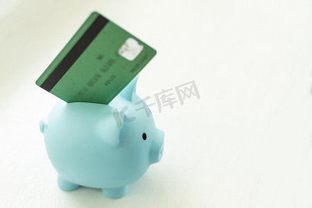 办公室桌面上的存钱罐和信用卡：储蓄、投资和银行存款概念。