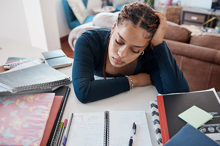 倦怠、疲倦和疲劳的学生在为大学、学校或大学考试学习时睡在办公桌上。