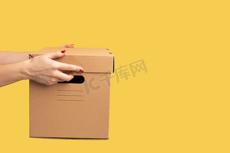 人手拿着纸板箱、纸箱包裹、交付概念的轮廓侧视图特写。