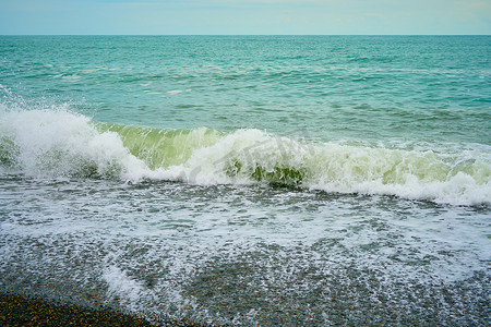 海岸有卵石、海滩上湿海卵石和安静的海浪