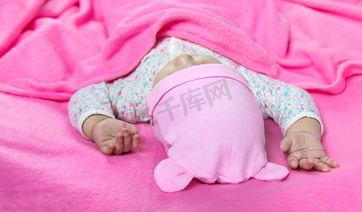 睡觉婴儿摄影照片_宝宝睡在粉红色的床上。