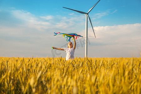 夏天，快乐的小女孩带着风筝在麦田里奔跑。