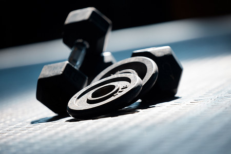 在空荡荡的健康和体育俱乐部的地板上，一组健身房举重的特写。