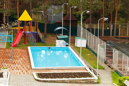 林中别墅摄影照片_乡村别墅设有游泳池和游乐场，可在森林中放松身心