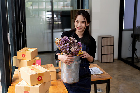 年轻创业亚洲女商人担任中小企业企业家新业务，带包装盒、花店