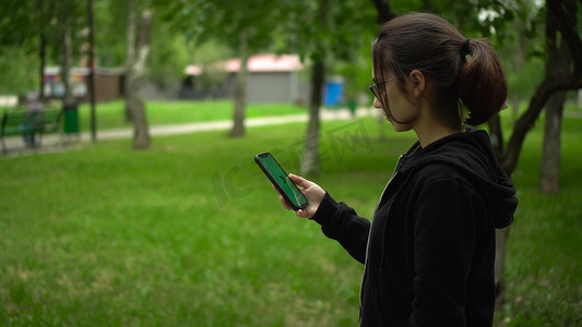 俄罗斯萨马拉 - 2022 年 7 月 20 日：一名年轻女子启动了 Stepn 应用程序并开始跑步。 