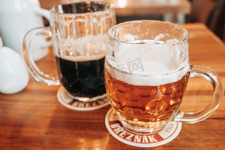 捷克共和国布拉格 — 2022年7月。酒吧里有两杯白啤酒和黑啤酒。