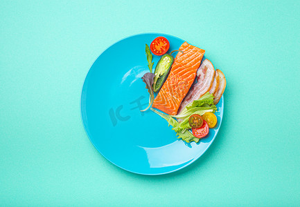 禁食icon摄影照片_间歇性禁食低碳水化合物高脂肪饮食概念平躺，蓝盘上的健康食品