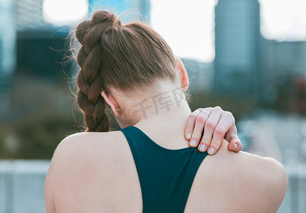 运动妇女摄影照片_一名白人妇女在户外锻炼时从后面抱着颈肩的特写镜头。