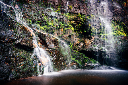 涉水摄影照片_蓝山国家公园的瀑布倾泻而下，流入岩石池