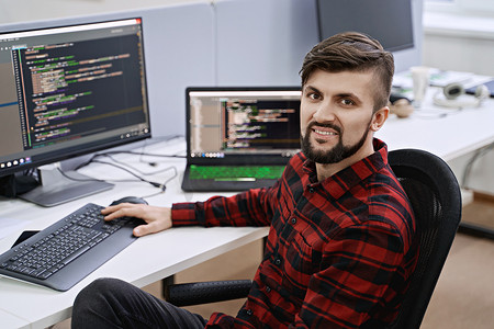 计算机程序员开发人员在 IT 办公室工作，坐在办公桌前编码，在软件开发公司或初创公司从事项目。