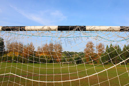 以足球场和秋季森林为背景的旧足球球门。