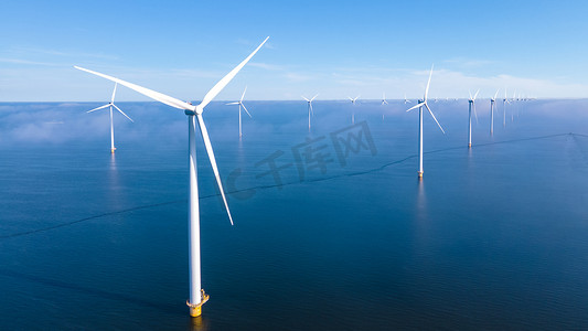 巨大的风车涡轮机、Westermeerwind 海洋公园的海上风车农场、荷兰弗莱福兰 Noordoostpolder 美丽明亮的日子里孤立在海上的风车