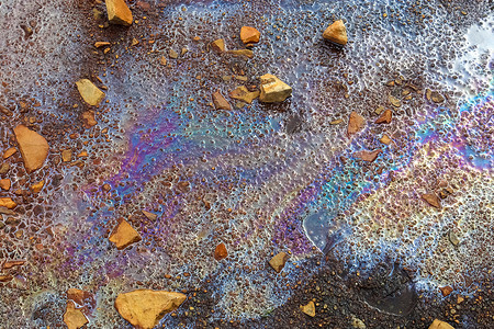 溅出摄影照片_沥青质地上的彩色燃料和石油显示出严重的环境污染。