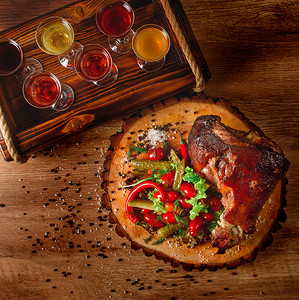 木板上的猪肘，配泡菜、沙拉、蔬菜、辣椒，背景是酒精眼镜