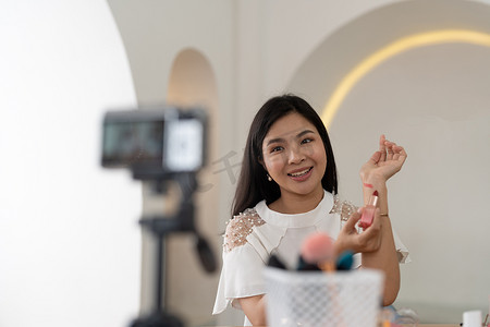 亚洲年轻女性博主在家中用化妆化妆品录制视频博客视频，在线影响社交媒体概念。直播病毒