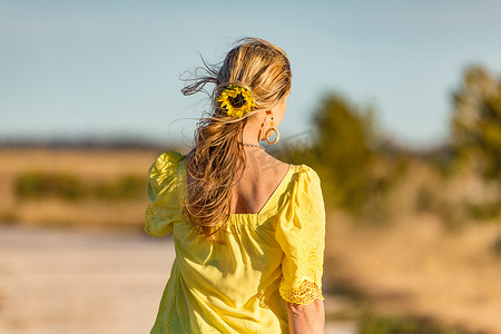 户外阳光下的女人，头发向日葵，波浪形的头发