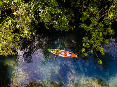 泰国甲米丛林中划皮划艇的情侣，甲米红树林阿甘热带丛林中划皮划艇的男女