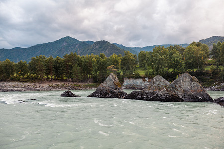 瀑布水流摄影照片_一条水流湍急、宽阔、水流充足的山间河流。