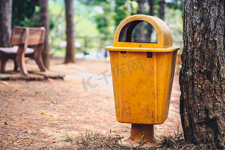 公共生活摄影照片_森林公园的黄橙色垃圾桶有助于避免道路两侧的公共垃圾。