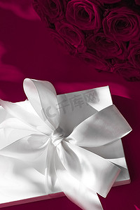 生日摄影照片_豪华假日丝绸礼盒和葡萄酒背景玫瑰花束、浪漫惊喜和鲜花作为生日或情人节礼物