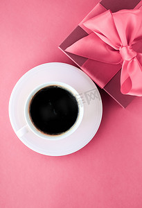 浪漫送礼摄影照片_粉色背景的豪华礼盒和咖啡杯，平铺设计，带来浪漫假日早晨的惊喜