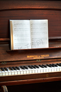 音符摄影照片_古典音乐节上有音符的旧老式钢琴。