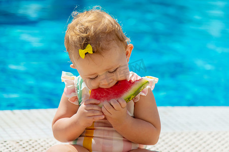 宝宝正在泳池边吃西瓜。