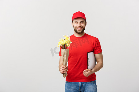 送花的手摄影照片_交付概念：快乐的送花人拿着美丽的花束，在白色背景上用手指指着相机的肖像