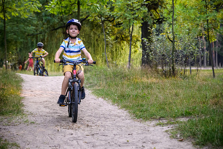两个小男孩在乡村道路上骑平衡自行车玩得很开心。