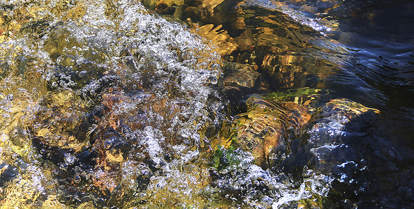 从大自然中看到的瀑布流入流过岩石的水流。