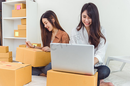 年轻的亚洲女性创业小企业企业家中小企业配送仓库，配有包裹邮箱。