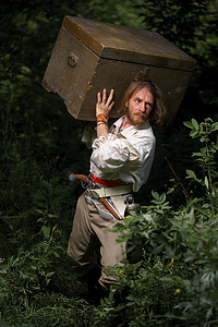 海贼王本子摄影照片_海贼船长武装海盗带着宝箱穿过丛林。