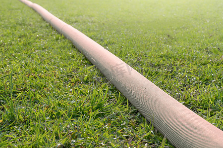 运动场草坪上的工业软管。