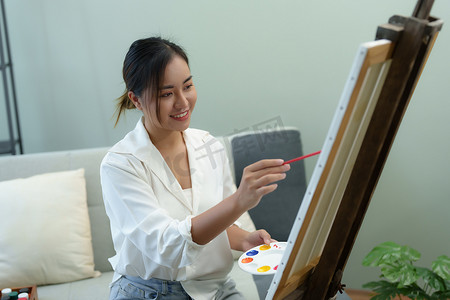 学生画画摄影照片_一位亚洲女性在业余时间设计艺术的肖像。