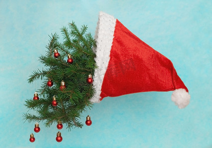 圣诞节最小和悬浮创意，圣诞树在蓝色背景下空中的圣诞老人帽子，软选择性焦点