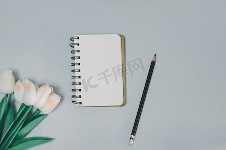顶视图空白记事本花和铅笔在桌子上。
