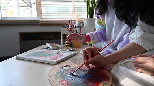 两个女孩一起在家度过周末，喜欢用水彩画画。