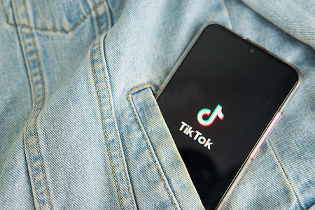 俄罗斯特维尔 - 2020 年 5 月 7 日，智能手机屏幕上的 Tik Tok 标志从牛仔夹克的口袋里伸出。