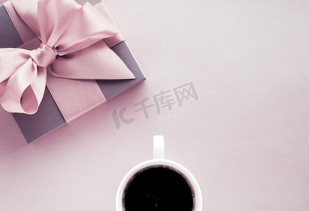 浪漫送礼摄影照片_腮红粉色背景的豪华礼盒和咖啡杯，平铺设计，适合浪漫假期和生日惊喜