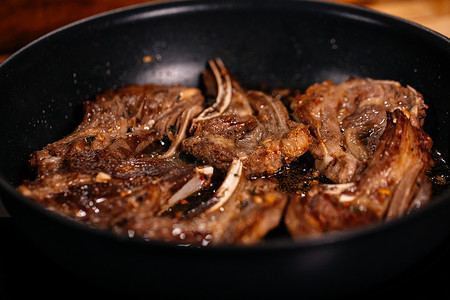煎牛排摄影照片_羊肉烹饪。