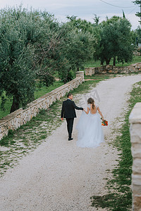 幸福的时尚微笑夫妇在婚礼当天漫步在意大利托斯卡纳。