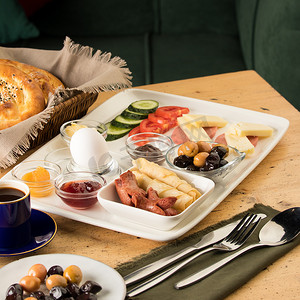 木桌上的早餐盘和一篮面包