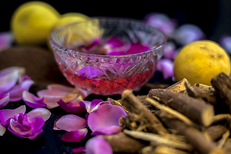 在黑色表面上特写古老草药 Mulethi 的面膜，让皮肤焕发光彩，由一些柠檬汁、甘草粉、玫瑰水和一些檀香粉组成。