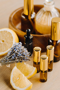 香水柠檬摄影照片_木质表面上装有柠檬和薰衣草香味的瓶子里的精油