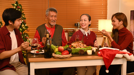 快乐的家庭在餐桌上交谈和庆祝圣诞节。