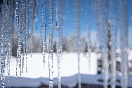 蓝色的波摄影照片_冬天的冰柱，背景模糊，气温寒冷，水结冰