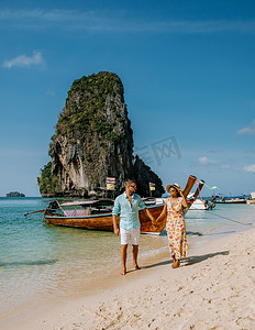 宝船摄影照片_泰国甲米，一对中年亚洲女人和欧洲男人在海滩上，
